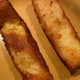 A Wendy's French toast stick and a Burger King French toast stick sit next to each other on a plate.